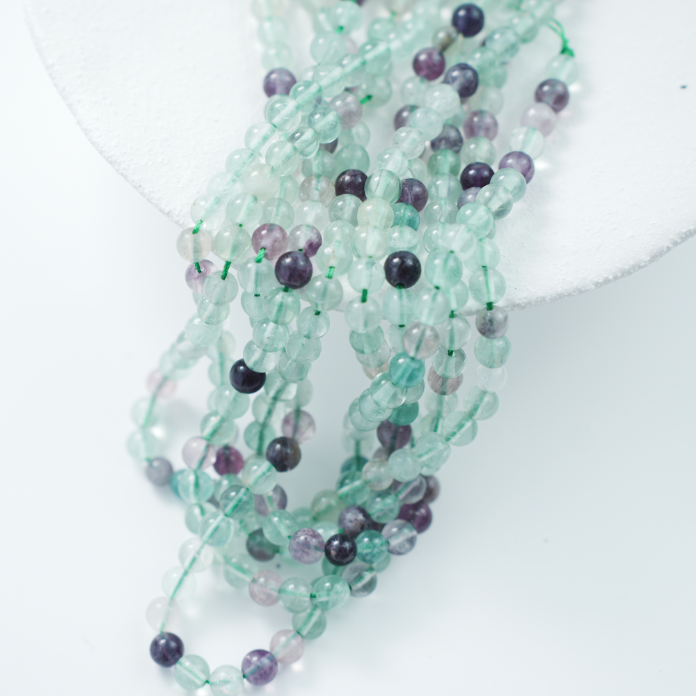 Fluorescerende Kvarts，6mm rund，hel streng 37cm